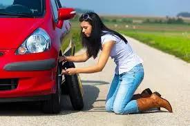 Mujer cambiando la llanta del auto&nbsp;